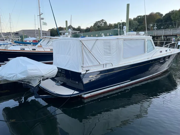 Liberty Yacht Photos Pics 2013 MJM 40z Downeast boat docked in a marina, covered with white tarps.