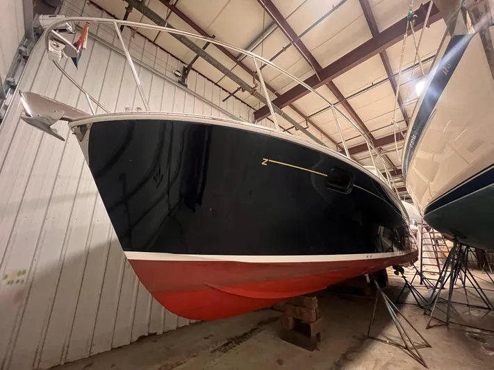 Liberty Yacht Photos Pics 2013 MJM 40z Downeast boat in indoor storage, showcasing sleek design and red hull.