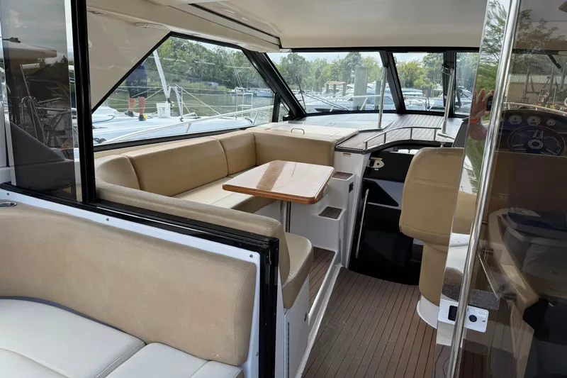  Yacht Photos Pics Interior of 2010 Regal 44 Sport Coupe yacht with beige seating and wooden table.