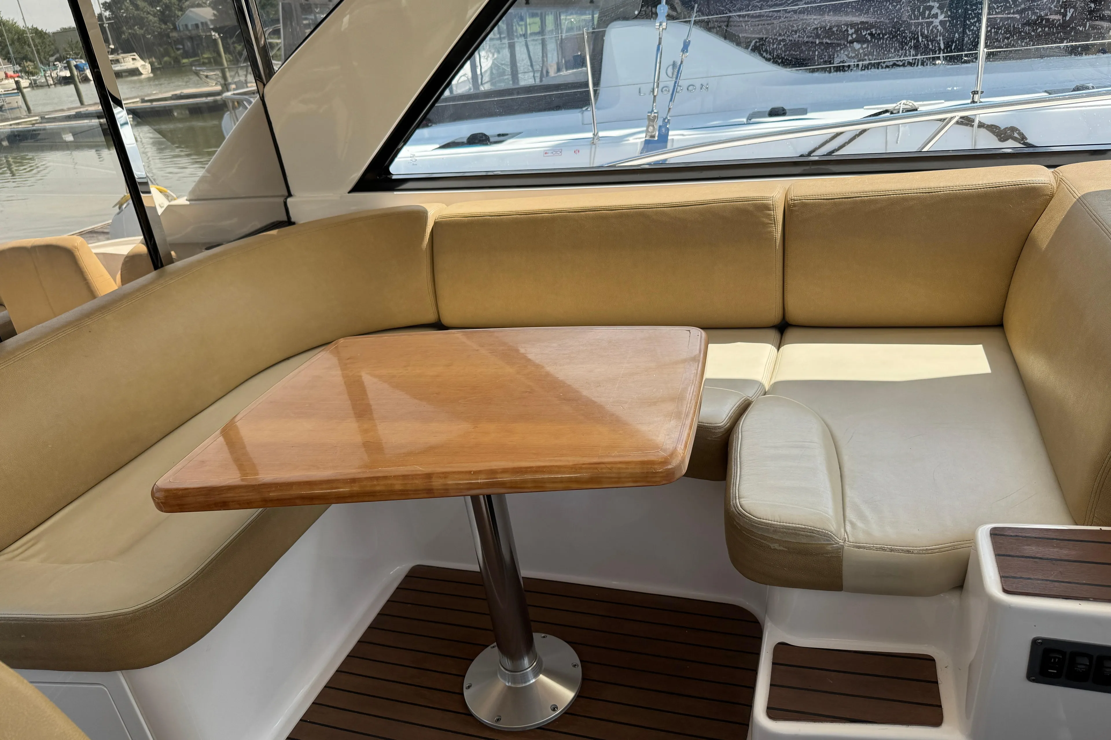 Interior of 2010 Regal 44 Sport Coupe with beige seating and wooden table.