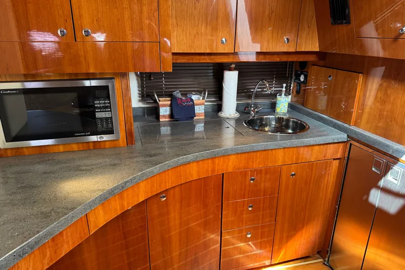  Yacht Photos Pics Luxurious 2010 Regal 44 Sport Coupe yacht kitchen with wood cabinetry and modern appliances.