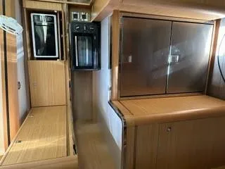  Yacht Photos Pics Interior of 2018 Dufour 512 Grand Large yacht kitchen with wood finish and modern appliances.