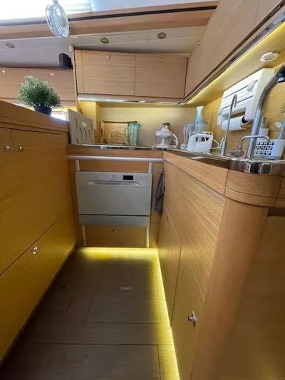  Yacht Photos Pics Modern kitchen interior of 2018 Dufour 512 Grand Large yacht with wooden cabinetry.