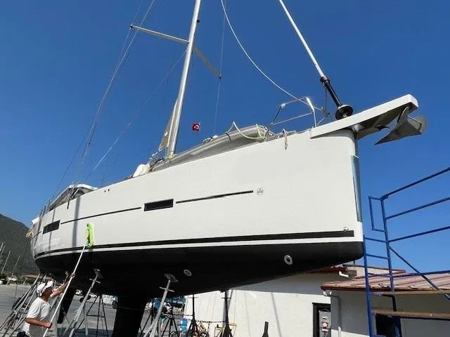  Yacht Photos Pics 2018 Dufour 512 Grand Large sailboat on dry dock under clear blue sky.