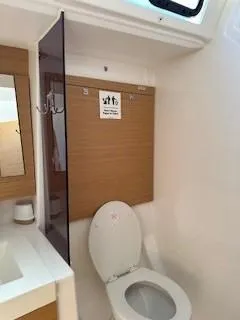  Yacht Photos Pics 2018 Dufour 512 Grand Large yacht bathroom with modern fixtures and wooden accents.