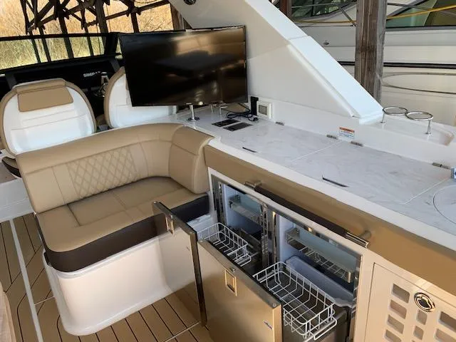  Yacht Photos Pics 2022 Sea Ray SLX 400 yacht interior with seating, TV, and open storage compartments.
