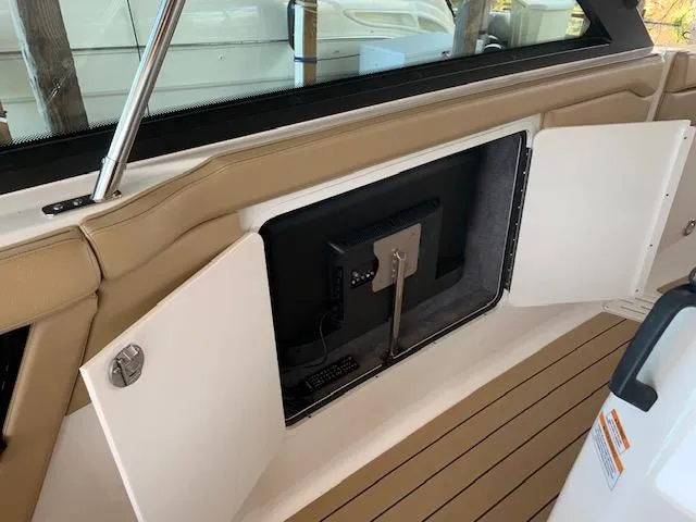  Yacht Photos Pics 2022 Sea Ray SLX 400 interior with open storage compartment and mounted screen.