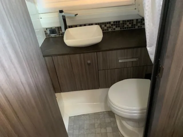  Yacht Photos Pics Modern bathroom interior on 2022 Sea Ray SLX 400 yacht, featuring sleek sink and toilet.