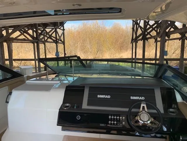  Yacht Photos Pics 2022 Sea Ray SLX 400 helm with Simrad displays, docked under wooden structure.