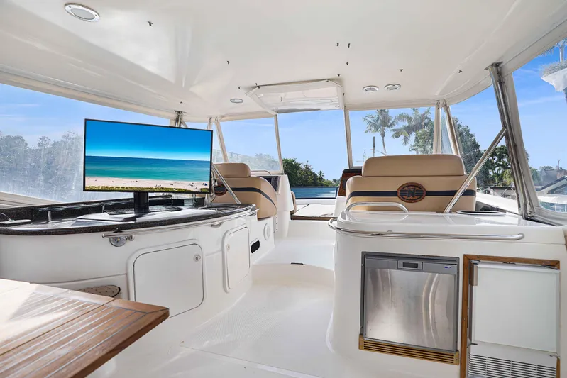 Carrie Ann Yacht Photos Pics Luxurious 2006 Neptunus 62 Flybridge interior with TV, seating, and outdoor view.