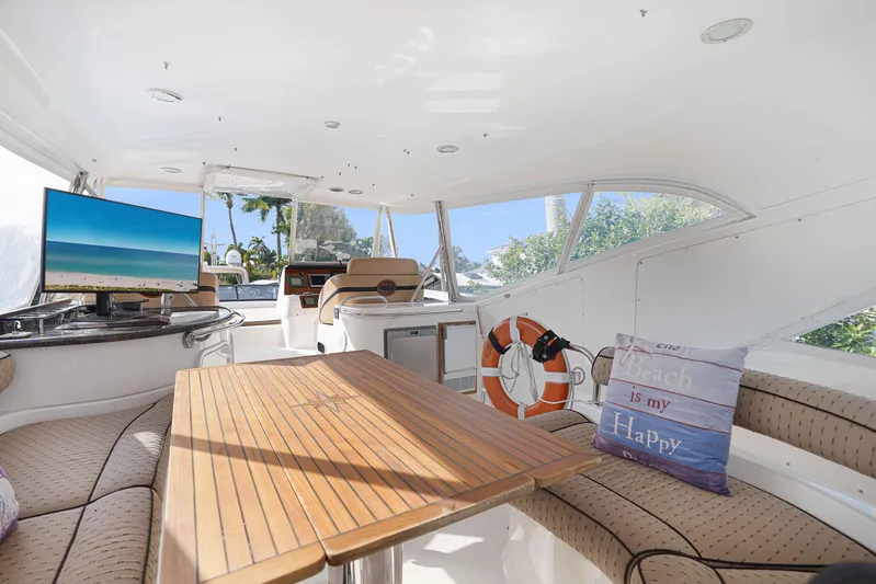 Carrie Ann Yacht Photos Pics Luxurious 2006 Neptunus 62 Flybridge interior with seating, table, and scenic views.