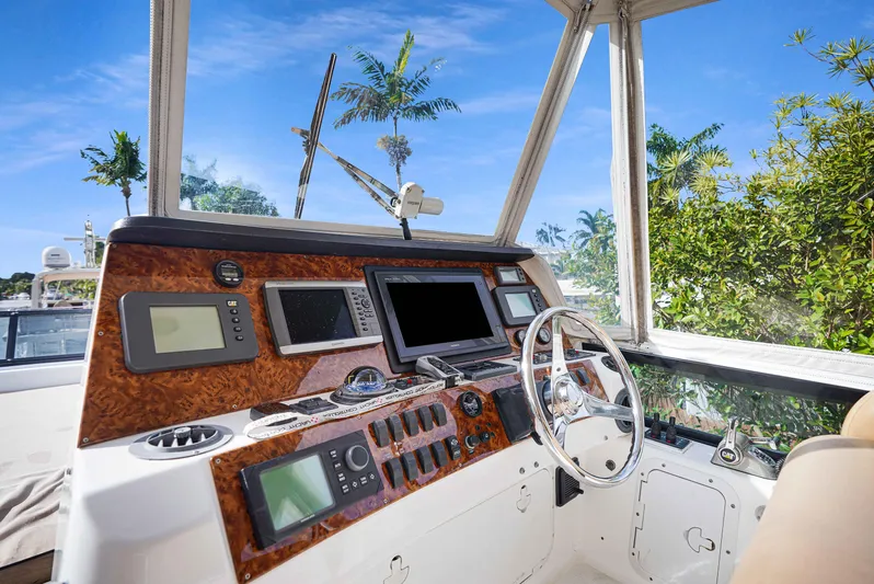 Carrie Ann Yacht Photos Pics Helm of 2006 Neptunus 62 Flybridge yacht with navigation equipment and steering wheel.