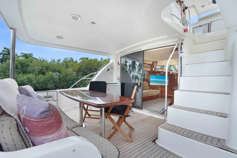 Carrie Ann Yacht Photos Pics Luxurious 2006 Neptunus 62 Flybridge yacht with elegant outdoor seating and staircase.