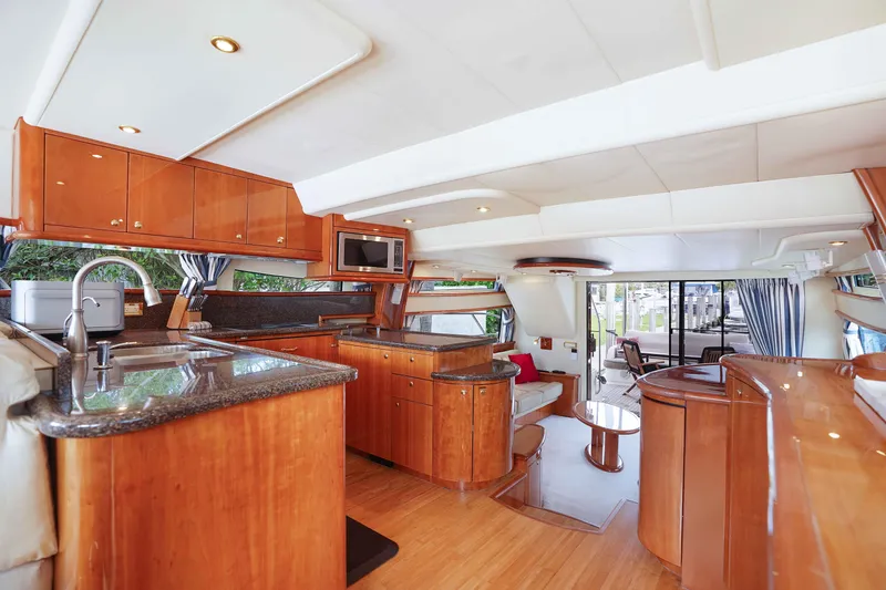 Carrie Ann Yacht Photos Pics Luxurious interior of 2006 Neptunus 62 Flybridge yacht with modern kitchen and seating area.