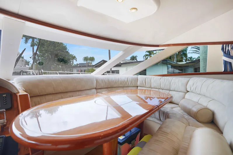 Carrie Ann Yacht Photos Pics Luxurious interior of 2006 Neptunus 62 Flybridge yacht with plush seating and wooden table.