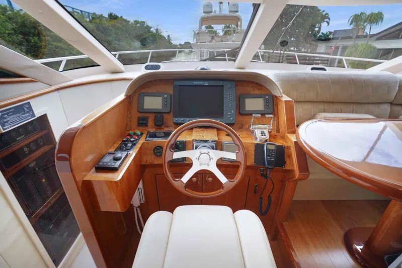 Carrie Ann Yacht Photos Pics Helm of 2006 Neptunus 62 Flybridge yacht with wooden dashboard and steering wheel.