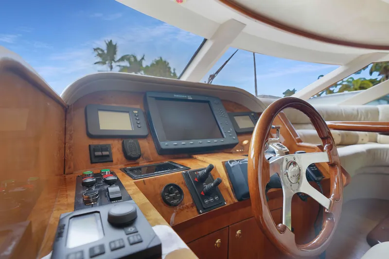 Carrie Ann Yacht Photos Pics Helm of 2006 Neptunus 62 Flybridge yacht with wooden steering wheel and navigation instruments.