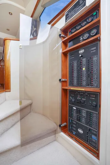 Carrie Ann Yacht Photos Pics Electrical panel on 2006 Neptunus 62 Flybridge yacht, near carpeted stairs.