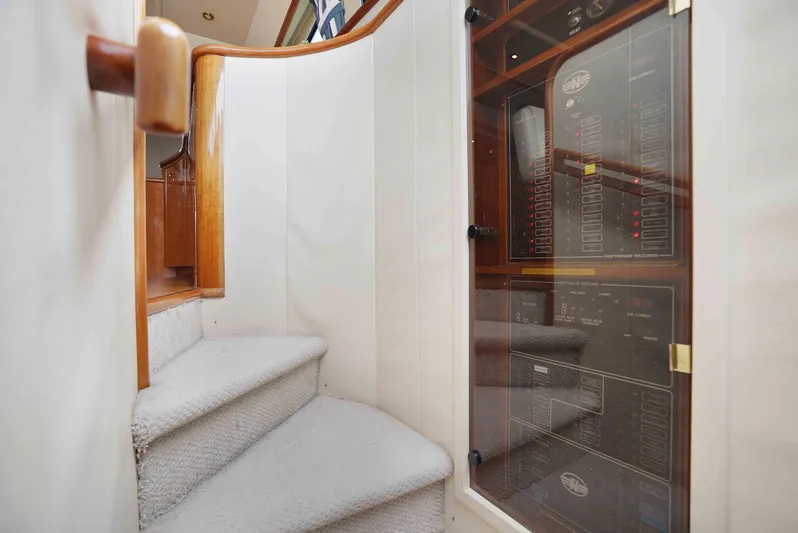 Carrie Ann Yacht Photos Pics Staircase inside 2006 Neptunus 62 Flybridge yacht with wooden handrail and control panel.