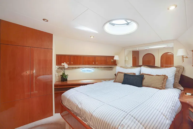 Carrie Ann Yacht Photos Pics Luxurious bedroom interior of 2006 Neptunus 62 Flybridge yacht with elegant wood finishes.
