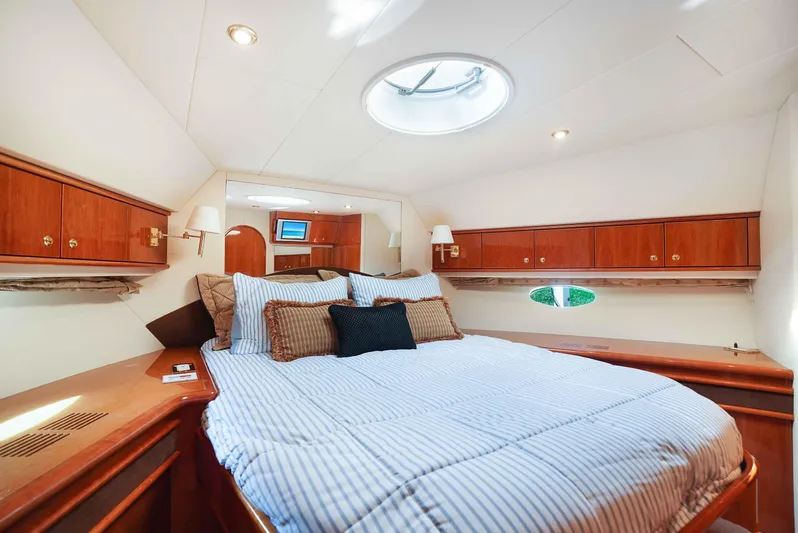 Carrie Ann Yacht Photos Pics Luxurious bedroom interior of 2006 Neptunus 62 Flybridge yacht with elegant wood finishes.