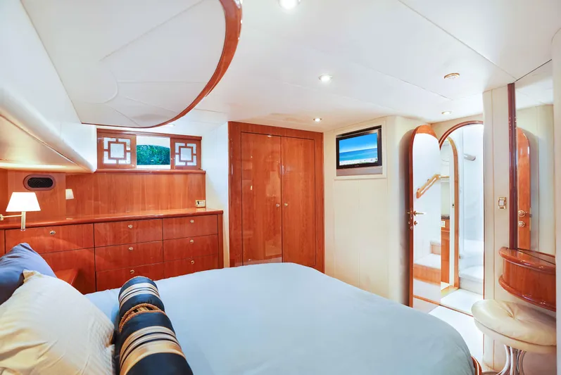 Carrie Ann Yacht Photos Pics Luxurious bedroom interior of 2006 Neptunus 62 Flybridge yacht with elegant wood finishes.