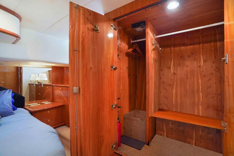 Carrie Ann Yacht Photos Pics Luxurious wooden interior of 2006 Neptunus 62 Flybridge yacht bedroom with open closet.