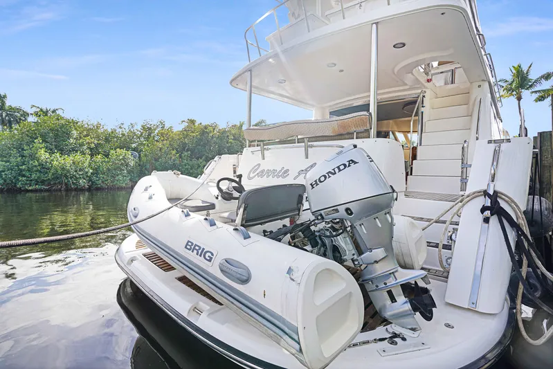 Carrie Ann Yacht Photos Pics 2006 Neptunus 62 Flybridge yacht with Honda-powered Brig tender on water.