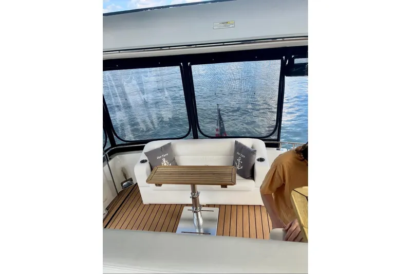 Our Turn Yacht Photos Pics 2001 Carver 396 Aft Cabin Motor Yacht interior with seating and table, overlooking water.