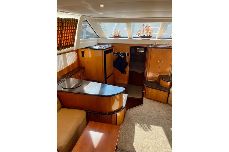 Our Turn Yacht Photos Pics Luxurious interior of 2001 Carver 396 Aft Cabin Motor Yacht with wood finishes and model ships.