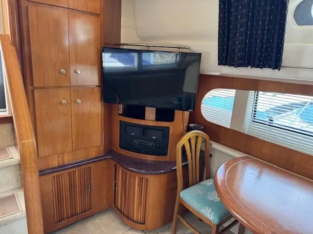 Wahooy Yacht Photos Pics Interior of 2001 Carver 396 Motoryacht with TV, wooden cabinets, and dining area.