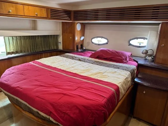 Wahooy Yacht Photos Pics Interior of 2001 Carver 396 Motoryacht bedroom with bed and wooden cabinetry.