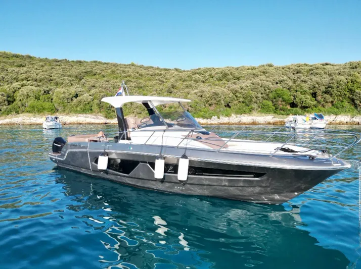  Yacht Photos Pics 2022 Sessa Marine Key Largo 40 yacht on clear blue water, near a lush shoreline.