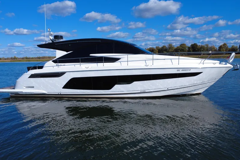  Yacht Photos Pics 2023 Fairline Targa 50 yacht on calm water under a blue sky.