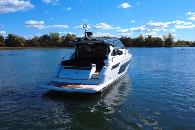  Yacht Photos Pics 2023 Fairline Targa 50 yacht on a serene lake under a clear blue sky.