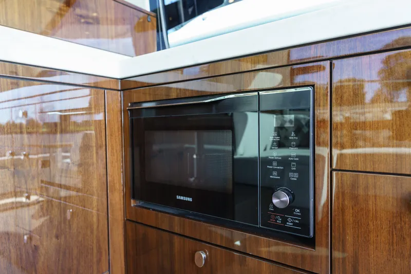 Yacht Photos Pics Built-in Samsung microwave in 2023 Fairline Targa 50 yacht's wooden kitchen interior.