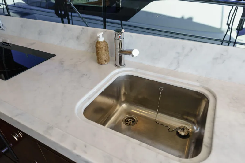  Yacht Photos Pics Modern kitchen sink on Fairline Targa 50 yacht, 2023 model, with marble countertop.