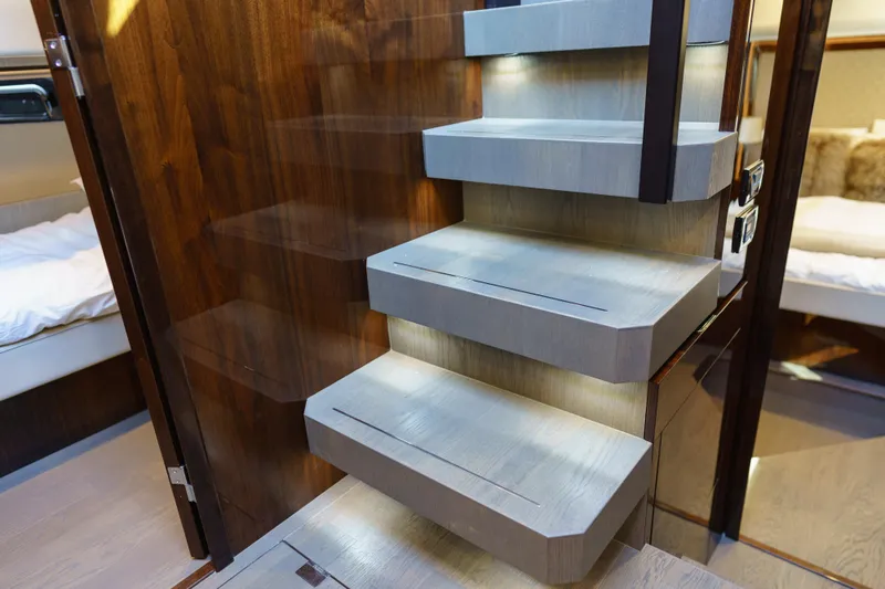 Yacht Photos Pics Modern interior staircase on 2023 Fairline Targa 50 yacht, featuring sleek wood design and ambient lighting.