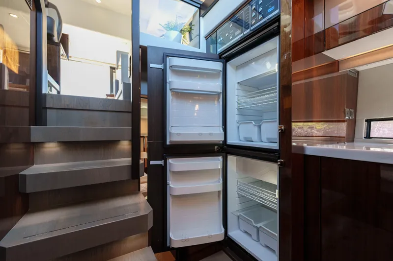  Yacht Photos Pics Modern kitchen interior of 2023 Fairline Targa 50 yacht with open refrigerator.