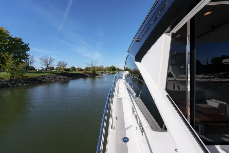  Yacht Photos Pics 2023 Fairline Targa 50 yacht cruising on a serene river under a clear blue sky.