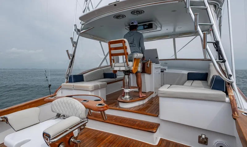  Yacht Photos Pics 2005 Gamefisherman 45 Express boat interior with captain at helm, featuring wooden and cushioned seating.