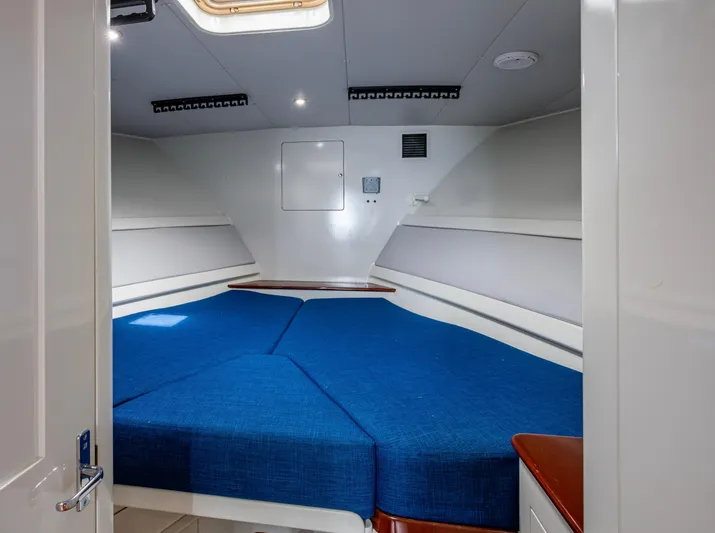  Yacht Photos Pics 2005 Gamefisherman 45 Express cabin with blue bedding and modern interior design.