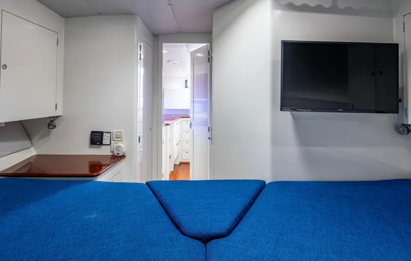  Yacht Photos Pics Interior of 2005 Gamefisherman 45 Express with blue seating, TV, and white cabinetry.