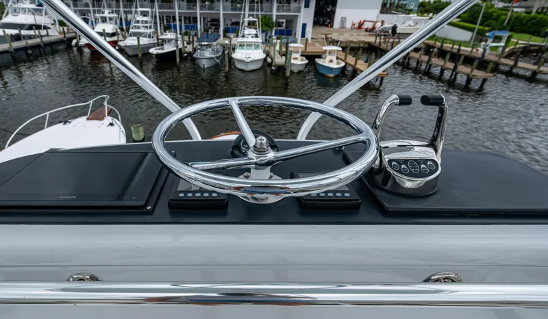  Yacht Photos Pics Helm of 2005 Gamefisherman 45 Express with chrome steering wheel and controls, docked at marina.