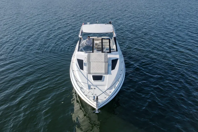  Yacht Photos Pics 2019 Regal 35 Sport Coupe cruising on calm waters, aerial view.