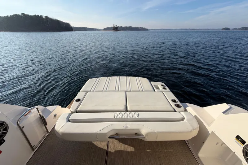  Yacht Photos Pics 2019 Regal 35 Sport Coupe boat with sunpad, overlooking serene lake view.