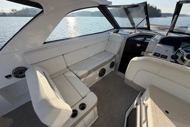  Yacht Photos Pics 2019 Regal 35 Sport Coupe interior with white seating, lake view, and modern dashboard.