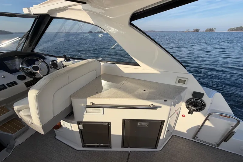  Yacht Photos Pics 2019 Regal 35 Sport Coupe interior with helm and seating, overlooking serene water.