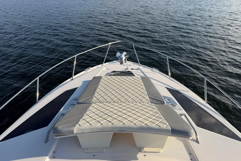  Yacht Photos Pics 2019 Regal 35 Sport Coupe boat with sunpad on calm water.