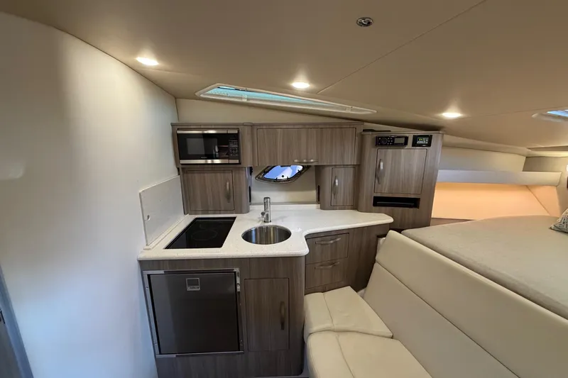  Yacht Photos Pics 2019 Regal 35 Sport Coupe interior with modern kitchenette and cozy seating area.